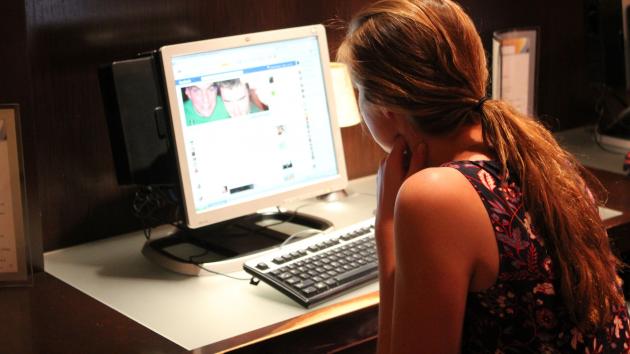 A woman checks her Facebook page at her apartment's computer room in Washington, DC. (UPI/Billie Jean Shaw)