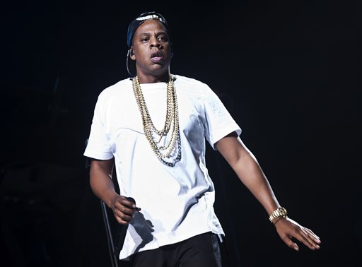 FILE - In this Oct. 10, 2013 file photo, U.S singer Jay Z performs on stage at the o2 arena in east London, as part of his Magna Carta World Tour. The rapper says hell continue his collaboration with Barneys despite allegations that black shoppers were racially profiled at the high-end retailer. Jay Z said in a statement Friday, Nov. 15, 2013, that hes agreed to move forward with next weeks launch of his BNY SCC collection under the condition he helps lead the stores review of its policies. He says hes in a unique position to effect change. (Photo by Joel Ryan/Invision/AP, File)
