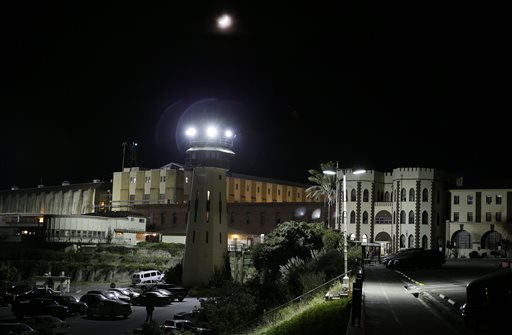 In this Thursday, Nov. 7, 2013 photo, a moon shines over San Quentin State Prison in San Quentin, Calif. The Last Mile program trains selected prisoners for eventual employment in a paid internship program within the Silicon Valley technology sector. Through twice-weekly sessions at the prison over a six-month period, the program provides information and practical experiences to increase knowledge and awareness about the role of social media, build skills in relevant areas for employment in the high-tech sector and foster confidence and a sense of hope that they can succeed as free men. (AP Photo/Eric Risberg)