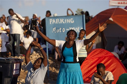 In this Feb. 8, 2014 photo, a Christian pilgrim  cries as she prays at a religious gathering organized by Our Lady of Fatima Bible Center  in the village of Bois-Neuf, Haiti. Although the center is Roman Catholic, the event had an evangelical feel, and some elements of Voodoo. (AP Photo/Dieu Nalio Chery)