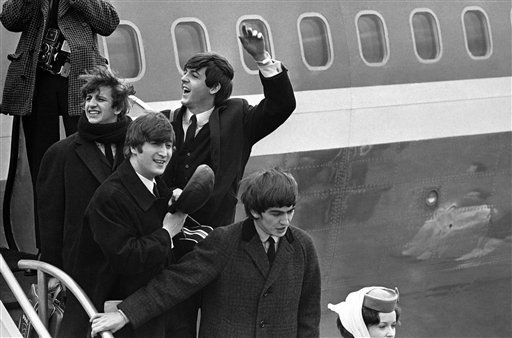 Britain's Beatles make a windswept arrival in New York in this  Feb. 7, 1964 file photo, as they step down from the plane that brought them from London, at Kennedy airport. From left to right, Ringo Starr, John Lennon, Paul McCartney and George Harrison. (AP Photo, File)
