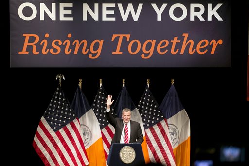 New York Mayor Bill de Blasio waves to the audience a he walks to the podium to deliver the State of the City address at LaGuardia Community College in the Queens borough of New York, Monday, Feb. 10, 2014. (AP Photo/Mark Lennihan)