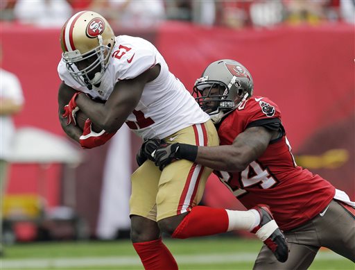 FILE - In this Dec. 15, 2013, file photo, San Francisco 49ers running back Frank Gore (21) is grabbed by Tampa Bay Buccaneers cornerback Darrelle Revis (24) during the first quarter of an NFL football game in Tampa, Fla. (AP Photo/Chris O'Meara, File)