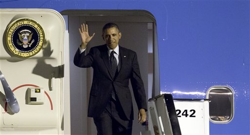 U.S. President Barack Obama waves as arrives from Air Force One at Zaventem airport in Brussels on Tuesday, March 25, 2014. (AP Photo/Virginia Mayo)