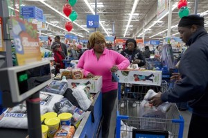 In this Wednesday, Dec. 4, 2013, file photo, April Taylor of Upper Marlboro, Md., left, buys items from groceries to Christmas presents with her son Jarhon Taylor, right, on opening day of a new Wal-Mart on Georgia Avenue in Northwest Washington. (AP Photo/Jacquelyn Martin, File)