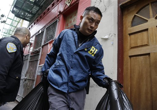 An FBI agent carries away bags of evidence following a search of a Chinatown fraternal organization Wednesday, March 26, 2014, in San Francisco. A California state senator was arrested Wednesday during a series of raids by the FBI in Sacramento and the San Francisco Bay Area, authorities said.  (AP Photo/Eric Risberg)
