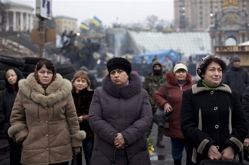 People attend a funeral ceremony for Andryi Pozniak, 25, a self defense volunteer who was shot and killed by an unknown assailant two days ago near Kiev's Independence Square, Ukraine, Thursday, March 6, 2014. (AP Photo/David Azia)