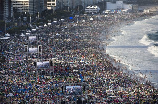 In this file photo taken on July 27, 2013, pilgrims and residents gather on Copacabana beach before the arrival of Pope Francis for World Youth Day in Rio de Janeiro, Brazil.  (AP Photo/Felipe Dana)