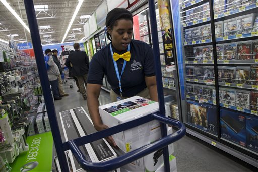 In this Wednesday, Dec. 4, 2013, file photo, Tracey Anderson, 26, re-stocks X-Box sets on opening day of a new Wal-Mart on Georgia Avenue Northwest in Washington. (AP Photo/Jacquelyn Martin, File)