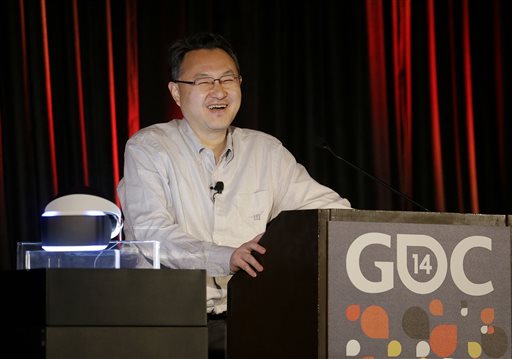 Shuhei Yoshida, president of Sony Computer Entertainment Worldwide Studios, speaks after unveiling the PlayStation 4 virtual reality headset Project Morpheus, pictured at left, at the Game Developers Conference 2014 in San Francisco, Tuesday, March 18, 2014.  (AP Photo/Jeff Chiu)