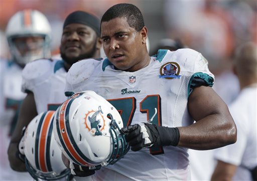 In this Dec. 16, 2012, photo, Miami Dolphins tackle Jonathan Martin (71) stands on the sidelines during the Dolphins' NFL football game against the Jacksonville Jaguars in Miami. Martin, the offensive tackle at the center of the Dolphins' bullying scandal, has been traded to the San Francisco 49ers. The Dolphins announced the deal Tuesday night, March 11, 2014, on the first day of NFL free agency. Martin's move cross country brings him back to the Bay Area to be reunited with his former Stanford coach, Jim Harbaugh. (AP Photo/Wilfredo Lee)
