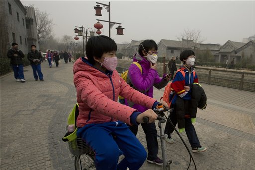 In this Tuesday, Feb. 25, 2014 file photo, children wearing masks walk home after school in Beijing, China. Air pollution kills about 7 million people worldwide every year according to a new report from the World Health Organization published Tuesday, March 25, 2014. The agency said air pollution triggers about 1 in 8 deaths and has now become the single biggest environmental health risk, ahead of other dangers like second-hand smoke. (AP Photo/Ng Han Guan, File)