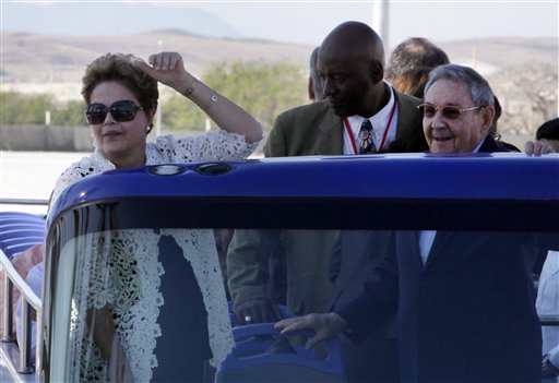 In this Jan. 27, 2014, file photo, Brazil's President Dilma Rousseff, left, and Cuba's President Raul Castro make a tour by bus after the inauguration ceremony of the first phase of a port overhaul project in Mariel, Cuba. Cuban authorities are on the verge of enacting a new foreign investment law considered one of the most vital building blocks of President Raul Castros effort to reform the countrys struggling economy. Foreign investment in the Communist-run country has lagged behind expectations in recent years, and the shortfall is seen as a major reason for disappointing economic growth. (AP Photo/Ismael Francisco, Cubadebate, File)