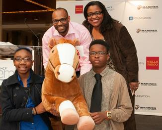 Wells Fargo leaders Dewey Norwood and Georgette “Gigi” Dixon photographed with two Charlotte students who received Mack, Wells Fargo’s commemorative 16oth anniversary pony during the UNCF Empower Me Tour.