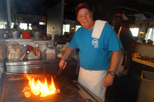 In this June 23, 2006 file photo, Uncle Bubba's Oyster House chef and owner Bubba Hiers, who is also Paula Deen's brother, grills oysters at the Savannah, Ga. restaurant. The wildly popular Georgia restaurant at the center of a lawsuit that left the reputation of famed Southern celebrity cook Paula Deen in shambles has reportedly closed. The Savannah Morning News and WSAV television both reported Thursday April 3, 2014 that Uncle Bubba's Seafood & Oyster House announced the closure on its Facebook page.  (AP Photo/Stephen Morton, File)