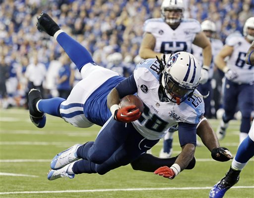 In this Dec. 1, 2013 file photo, Tennessee Titans' Chris Johnson (28) dives while being tackled by Indianapolis Colts' Cory Redding during the first half of an NFL football game in Indianapolis. (AP Photo/Michael Conroy, File)