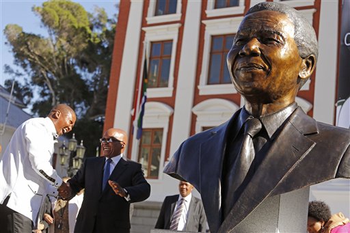 South African President Jacob Zuma, second left, talks with Mandla Mandela, left, after they and other dignitaries unveiled a bust of former South African President Nelson Mandela, right, at the South African Parliament in Cape Town, South Africa, Monday, April 28, 2014. South African President Jacob Zuma and members of the South African Parliament unveiled the bust of Mandela at Parliament, forming part of celebrations for 20-years anniversary of a democratic Parliament in South Africa after the end of white rule. (AP Photo/Schalk van Zuydam)
