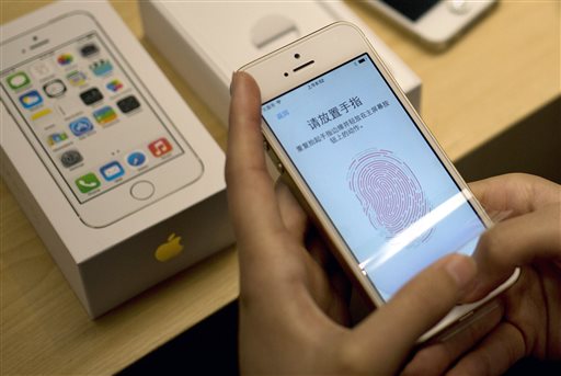 In this Sept. 20, 2013 file photo, a customer configures the fingerprint scanner technology built into iPhone 5S at an Apple store in Beijing. (AP Photo/Andy Wong, File)