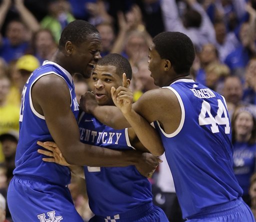 Kentucky's Aaron Harrison is congratulated by teammates Julius Randle and Dakari Johnson (44) after making a three-point basket in the final seconds of the second half of an NCAA Midwest Regional final college basketball tournament game against Michigan Sunday, March 30, 2014, in Indianapolis. Kentucky won 75-72 to advance to the Final Four. (AP Photo/David J. Phillip)