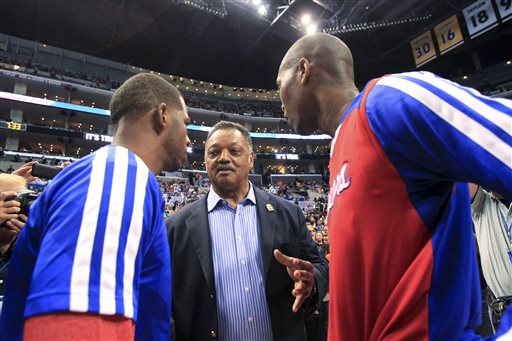 The Rev. Jesse Jackson, center, talks to Los Angeles Clippers' Chris Paul and Jamal Crawford before Game 5 of the Clippers' opening-round NBA basketball playoff series against the Golden State Warriors on Tuesday, April 29, 2014, in Los Angeles. NBA Commissioner Adam Silver announced Tuesday that Clippers owner Donald Sterling has been banned for life by the league. (AP Photo/Ringo H.W. Chiu)