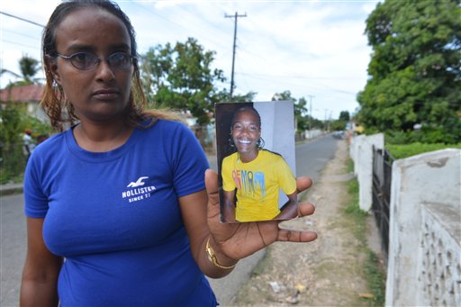 In this photo taken April 17, 2014, in the central Jamaican city of May Pen, Sevina Giderisingh holds a picture of her dead son, Alphanso. The 20-year-old was shot dead by a policeman in a confrontation on the dusty outskirts of this struggling city a few days after graduating from high school. Jamaicas security forces have long been accused of indiscriminate shootings and unlawful killings. But 27 police officers, including eight in May Pen, now face charges of murder brought by an investigative commission probing abuse allegations against Jamaicas security forces. (AP Photo/David McFadden)