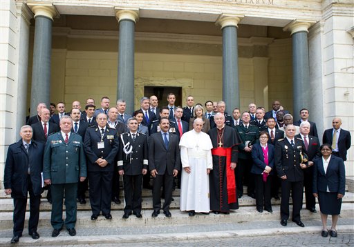 In this photo released by Vatican newspaper L'Osservatore Romano Pope Francis poses for a photo with participants in a conference about the human trafficking,  at the Vatican, Thursday, April 10, 2014. Pope Francis has denounced human trafficking as a crime against humanity after meeting with four women who were forced into prostitution.  Francis attended a Vatican conference Thursday of church workers, charity representatives and police chiefs from 20 nations, who pledged greater cooperation to encourage victims of trafficking and slavery to come forward.  (AP Photo/L'Osservatore Romano)