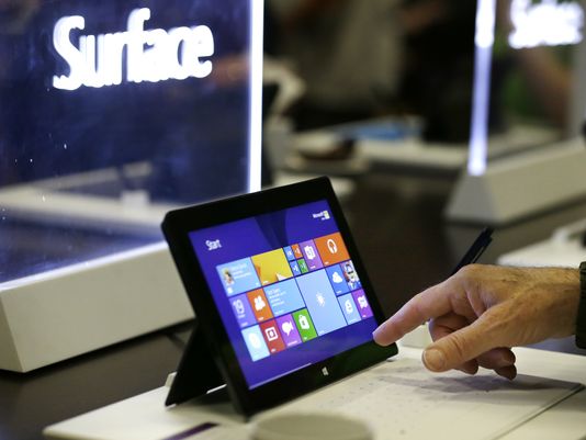 Microsoft shareholders look over Surface tablets on display before the annual shareholder meeting on Nov. 19, 2013, in Bellevue, Wash. (Photo: Elaine Thompson, AP)