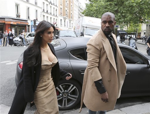 Kim Kardashian and U.S rap singer Kanye West arrive at a luxury shop in Paris, Wednesday, May 21, 2014.  The gates of the Chateau de Versailles, once the digs of Louis XIV, will be thrown open to Kim Kardashian, Kanye West and their guests for a private evening this week ahead of their marriage (AP Photo/Jacques Brinon)