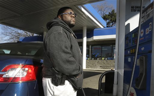 In a photo from April 9, 2014, Greg Champion wears a gun while pumping gas in Detroit. To avoid becoming a carjacking victim, Champion wears a handgun on his hip whenever hes pumping gas. Through May 19, Detroit has recorded 191 carjackings in 2014. (AP Photo/Carlos Osorio)
