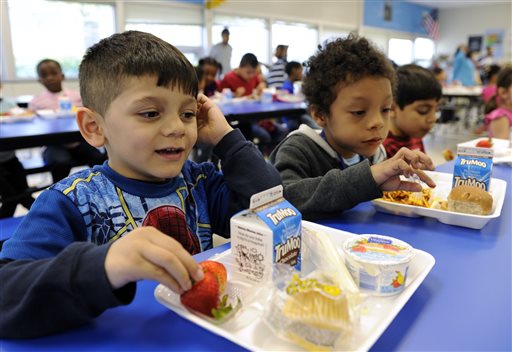 In this Tuesday, April 29, 2014 photo, Biden Arias-Romers, 5, left, and Nathaniel Cossio-Boatwright, 6, eat lunch at the Patrick Henry Elementary School in Alexandria, Va. Starting next school year, pasta and other grain products in schools will have to be whole-grain rich, or more than half whole grain. The requirement is part of a government effort to make school lunches and breakfasts healthier. (AP Photo/Susan Walsh)