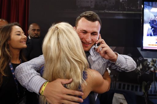 Johnny Manziel, from Texas A&M, is congratulated after being selected 22nd overall in the first round of the NFL football draft by the Cleveland Browns, Thursday, May 8, 2014, at Radio City Music Hall in New York. (AP Photo/Jason DeCrow)