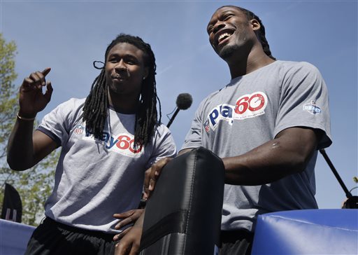 South Carolina's Jadeveon Clowney, right, and Clemson's Sammy Watkins teach tackling technique during an NFL football event in New York, Wednesday, May 7, 2014. The event was to promote Play 60, an NFL program which encourages kids to be active for a healthy life. (AP Photo/Seth Wenig)