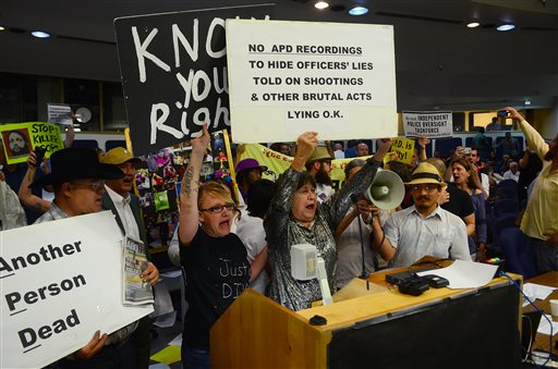 Protesters take over the City Council meeting, Monday May 5, 2014, in Albuquerque, N.M.  Alan Gomez was fatally shot by an APD officer in 2011. (AP Photo/The Albuquerque Journal, Bob Brawdy)
