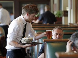 Waiter Spencer Meline serves a customer at Ivar's Acres of Clams restaurant on the Seattle waterfront on May 14, 2014. (AP Photo)