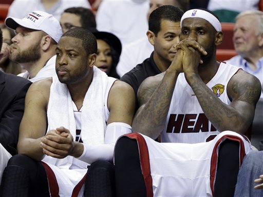 Miami Heat forward LeBron James, right and guard Dwyane Wade sit on the bench during the last minutes in the second half in Game 4 of the NBA basketball finals against the San Antonio Spurs, Thursday, June 12, 2014, in Miami.  The Spurs defeated the Heat 107-86. (AP Photo/Lynne Sladky)