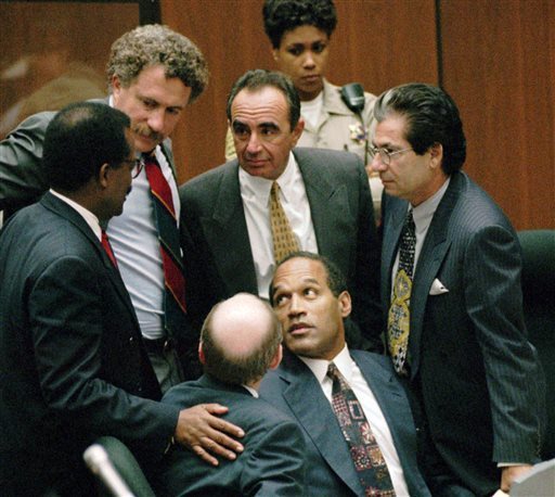 In this Sept. 28, 1995 file photo, O.J. Simpson is surrounded by his Dream Team defense attorneys from left, Johnnie L. Cochran Jr., Peter Neufeld, Robert Shapiro, Robert Kardashian, and Robert Blasier, seated at left, at the close of defense arguments in Los Angeles. (AP PHOTO/SAM MIRCOVICH, POOL, FILE)
