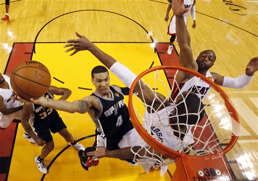 San Antonio Spurs guard Danny Green (4) drives to the basket over Miami Heat center Chris Bosh (1) and  guard Dwyane Wade (3)during the first half in Game 3 of the NBA basketball finals, Tuesday, June 10, 2014, in Miami. (AP Photo/Wilfredo Lee)