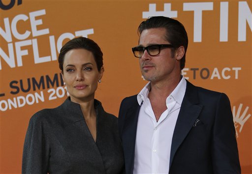 US actress Angelina Jolie, left, Special Envoy of the United Nations High Commissioner for Refugees, accompanied by her partner and US actor Brad Pitt pose for the photographers as they arrive at the 'End Sexual Violence in Conflict' summit in London, Friday, June 13, 2014. The Summit welcomes governments from over 100 countries, over 900 experts, NGOs, Faith leaders, and representatives from international organisations across the world. (AP Photo/Lefteris Pitarakis)