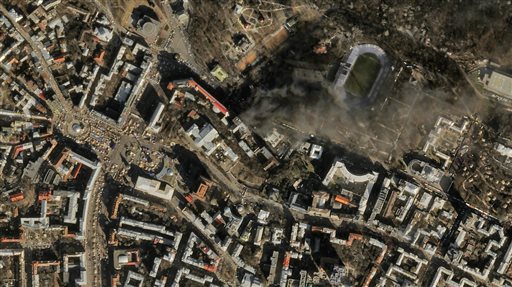 In this file satellite image provided by Skybox Imaging and taken by SkySat-1 on Tuesday, Feb. 18, 2014 at 11:10 a.m. local time, smoke rises from the site of anti-government protests, upper center, in Kiev, Ukraine. Google is buying Skybox Imaging in a deal that could serve as a launching pad for the Internet company to send its own fleet of satellites to take aerial pictures and provide online access to remote areas of the world. (AP Photo/Skybox Imaging, File)