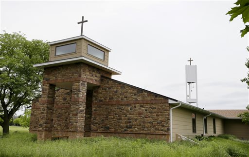 In this June 10, 2014 photo a cellphone tower inside the bell tower, rear right, is seen over the Resurrection Lutheran Church in Ankeny, Iowa. As wireless companies fill gaps in their networks, many have sought to camouflage the ungainly outdoor equipment that carries the nations daily diet of calls, text messages and data. (AP Photo/Charlie Neibergall)