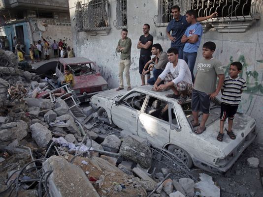 Palestinians look at a destroyed house where five members of the Ghannam family were killed in an Israeli missile strike early Friday morning in the Rafah refugee camp in the southern Gaza Strip (Khalil Hamra/AP)