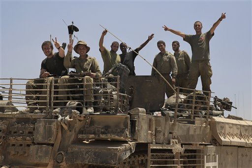 Israeli soldiers give the victory sign on the top of armored vehicle near the Israel Gaza border, Tuesday, July 29, 2014. Israel unleashed its heaviest bombardment in a 3-week-old war against Hamas on Tuesday, striking symbols of the militant group's control in Gaza and firing tank shells that Palestinian officials said shut down the strip's only power plant. (AP Photo/Tsafrir Abayov)