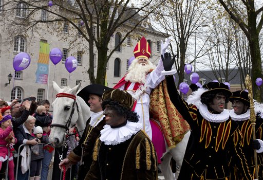 In this Nov. 17, 2013 file photo people line the road to watch the arrival of Sinterklaas, the Dutch version of Santa Claus, center, and his blackface sidekick "Zwarte Piet", or Black Pete, in Amsterdam. On Thursday, July 3, 2014, an Amsterdam court has stated the figure known as Black Pete is a negative stereotype and the city must rethink its involvement in holiday celebrations involving the figure. Debate over the figure of Black Pete has intensified in the Netherlands in recent years as opponents argue it is a racist caricature, while supporters say it is a harmless figure of fun. Thursdays ruling regards a specific challenge to the city of Amsterdams decision to grant a permit for an annual party attended by thousands of children. In Dutch tradition, St. Nicholas arrives by steamboat with scores of Petes handing out cookies and presents. (AP Photo/Peter Dejong, File)