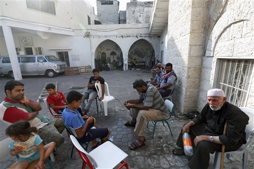 Palestinians sit on the grounds of the St. Porphyrios Church in Gaza City, Wednesday, July 23, 2014. St. Porphyrios Church has thrown its doors open to hundreds of displaced Palestinians. (AP Photo/Lefteris Pitarakis)