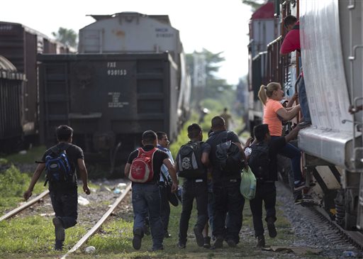 In this Saturday, July 12, 2014 file photo, immigrants run to jump on a train during their journey toward the U.S.-Mexico border, in Ixtepec, Mexico. Many of the immigrants recently flooding the nations southern border say theyre fleeing violent gangs in Central America. These gangs were a byproduct of U.S. immigration and Cold War policies, specifically growing from the increase in deportations in the 1990s. With weak dysfunctional governments at home, U.S. street gang culture easily took hold and flourished in these countries. (AP Photo/Eduardo Verdugo)