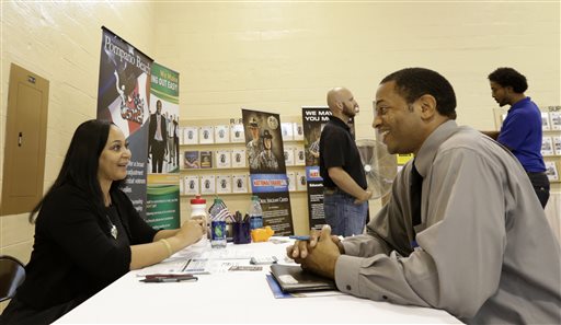 In this photo taken Wednesday, July 16, 2014, job seeker U.S. Air Force veteran Jesse Jefferson, Jr., right, talks to Arianna Alexander, of the Pompano Beach Veterans Center, at a Hiring Fair For Veterans in Fort Lauderdale, Fla. Florida led the nation in job growth in June, a sharp turnaround from the previous month. (AP Photo/Alan Diaz)