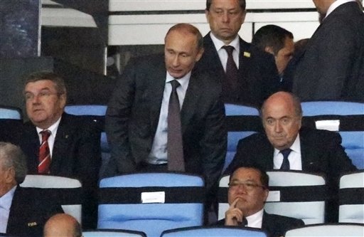 Russian President Vladimir Putin, standing, is flanked by IOC president Thomas Bach, left, and FIFA President Sepp Blatter while watching the World Cup final soccer match between Germany and Argentina at the Maracana Stadium in Rio de Janeiro, Brazil, Sunday, July 13, 2014. (AP Photo/Frank Augstein)