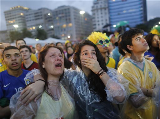 Brazil soccer fans cry as they watch their team play a World Cup semifinal match against Germany on a live telecast inside the FIFA Fan Fest area on Copacabana beach in Rio de Janeiro, Brazil, Tuesday, July 8, 2014. (AP Photo/Leo Correa)