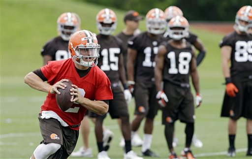 In this June 11, 2014, file photo, Cleveland Browns quarterback Johnny Manziel runs the ball during NFL football minicamp at the team's facility in Berea, Ohio. With LeBron James return, Johnny Football might not be the top star in Cleveland, but Manziel will still get plenty of attention for what he does on and off the field this summer.  (AP Photo/Mark Duncan, File)