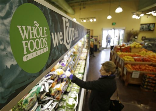 In this March 27, 2014 photo, a woman shops at the Whole Foods Market in Woodmere Village, Ohio. Whole Foods reports quarterly financial results on Wednesday, July 30, 2014. (AP Photo/Tony Dejak)
